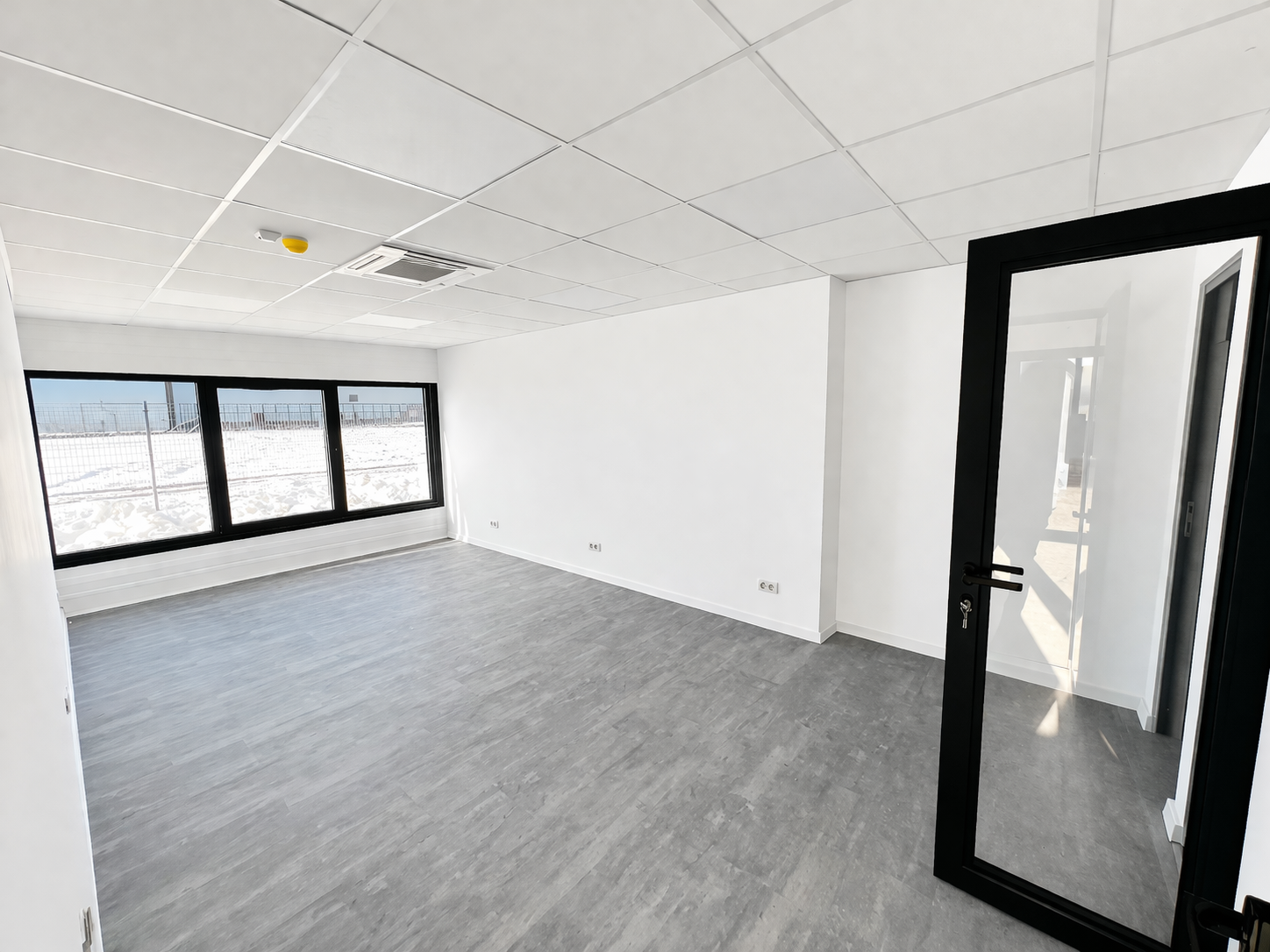 Modern office interior with gray flooring and large windows